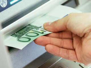 Close op of young woman withdrawing money from an atm