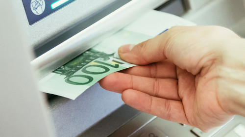 Close op of young woman withdrawing money from an atm