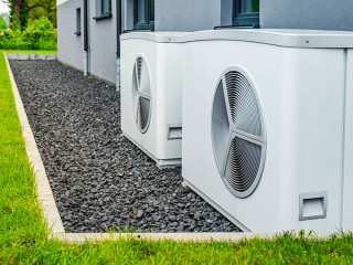 Two air source heat pumps installed outside of new and modern ci