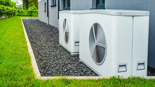 Two air source heat pumps installed outside of new and modern ci