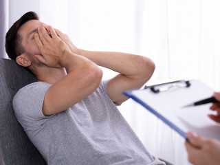 Psychologist Sitting Near Man Suffering From Depression