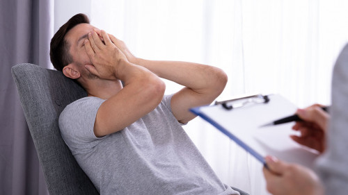 Psychologist Sitting Near Man Suffering From Depression