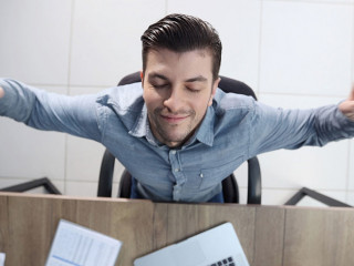 A male office worker is tired and warming up