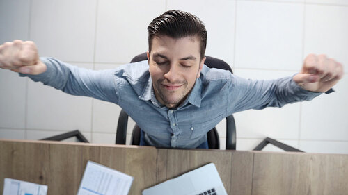 A male office worker is tired and warming up