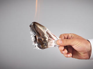 Businessman with a burning money in office.