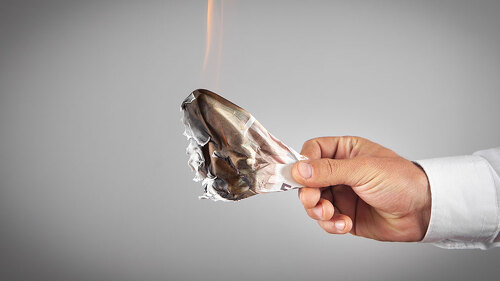 Businessman with a burning money in office.