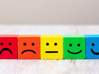 Emotion face symbol on yellow wooden cube blocks. Service rating