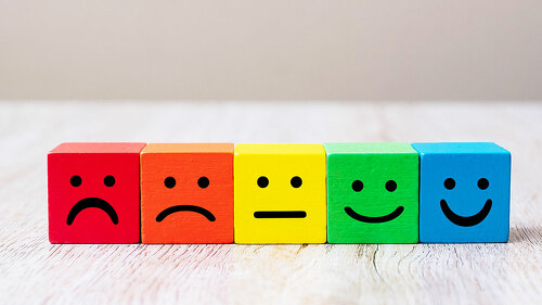 Emotion face symbol on yellow wooden cube blocks. Service rating
