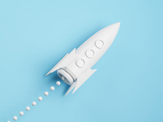 Startup and new project concept with white rocket flying up with dotted trajectory above light growth graph on blue background. 3D rendering