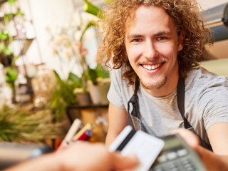 Kunde zahlt mit Kreditkarte bargeldlos beim Kassierer