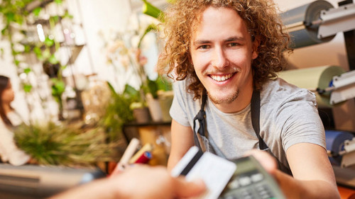 Kunde zahlt mit Kreditkarte bargeldlos beim Kassierer