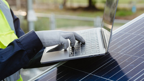 Engineer man working with laptop in solar panels.