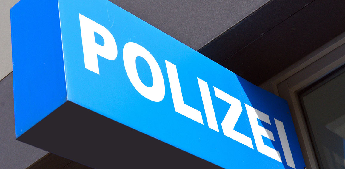 Schild mit Polizei Schriftzug an einer Polizeiwache