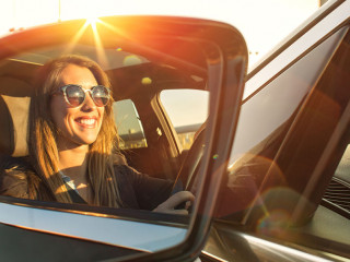Beautiful businesswoman in rear view mirror with sunglasses