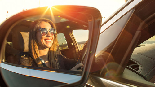 Beautiful businesswoman in rear view mirror with sunglasses