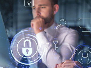 Two colleagues working together to protect clients confidential information and cyber security. IT hologram padlock icons modern office background at night time