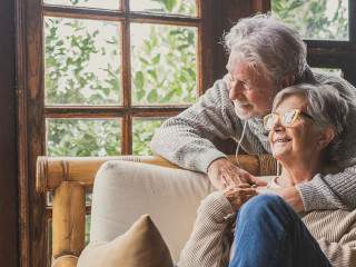 Old caucasian couple spending leisure time looking out through w