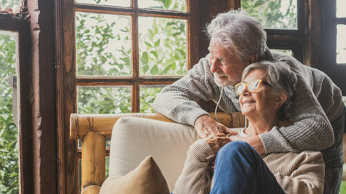 Old caucasian couple spending leisure time looking out through w