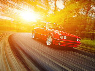 Classic red convertible sport car driving fast on the open road