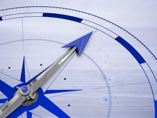 Compass against bleached wooden planks background