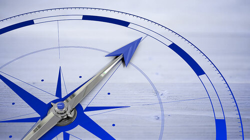 Compass against bleached wooden planks background