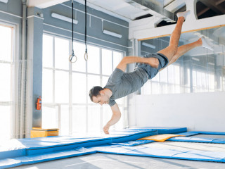 active young man is landing on mats during workout.