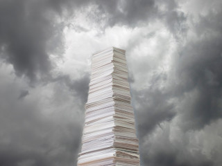Stack of paper against a stormy sky