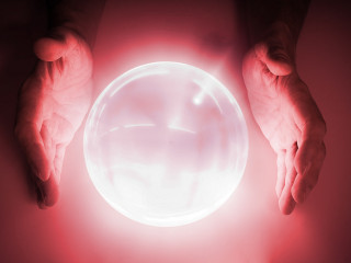 Magician or fortune teller is predicting future with crystal sph