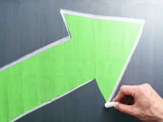 Businessman drawing yellow arrow on chalkboard. Business growth