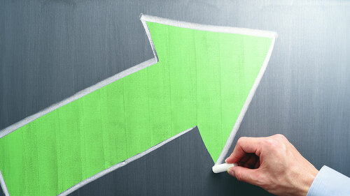 Businessman drawing yellow arrow on chalkboard. Business growth