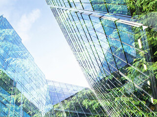 green city - double exposure of lush green forest and modern sky