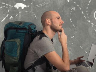 Explorer plans a new travel with his laptop