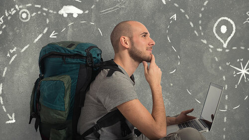 Explorer plans a new travel with his laptop