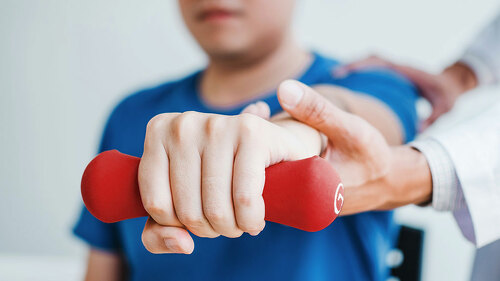 Physiotherapist man giving exercise with dumbbell treatment Abou
