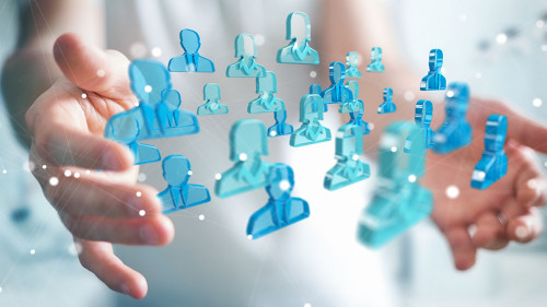 Businessman holding 3D rendering group of blue people