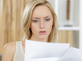 woman reading a letter with a concerned expression