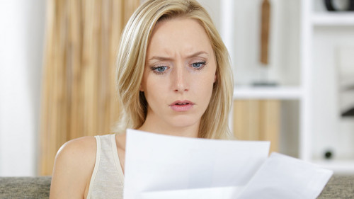 woman reading a letter with a concerned expression