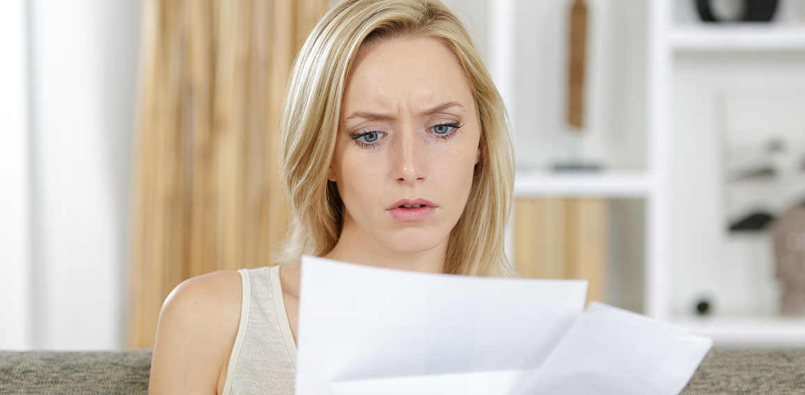 woman reading a letter with a concerned expression