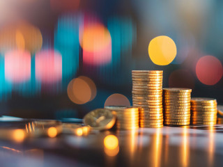 Stacks of coins with a blurred colorful bokeh light background,