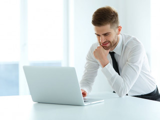 Handsome Businessman Working on Laptop at His Office