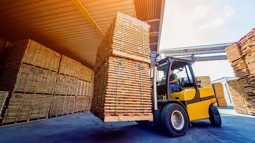 Forklift loader load lumber into a dry kiln. Wood drying in containers.