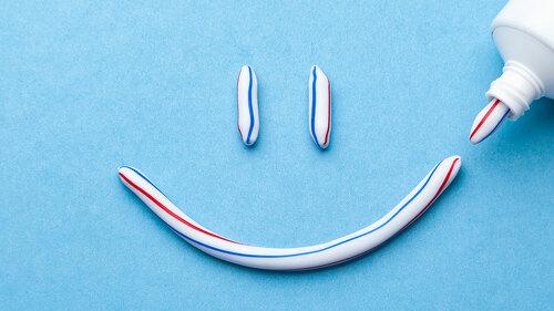 Tooth-paste in the form of a face with a smile. Tube of toothpas
