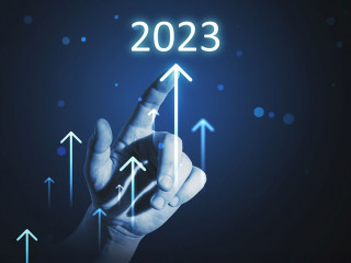 Hand touching year 2023 hologram over blue background. Business and technology concept
