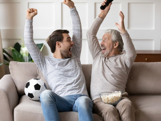 Excited man and old dad celebrate win watching football