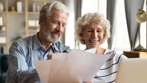 Senior couple use online banking on laptop planning family budget