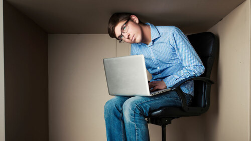teenager, student in small office working on laptop, in an uncom