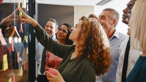 Diverse businesspeople brainstorming with sticky notes in an off