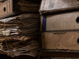 Old dusty stack of papers, files, documents on the shelves of ar