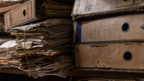 Old dusty stack of papers, files, documents on the shelves of ar