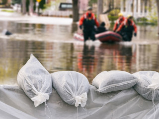 Flood Protection Sandbags with flooded homes in the background (